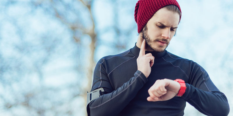 Man Jogging In Winter Checks His Pulse